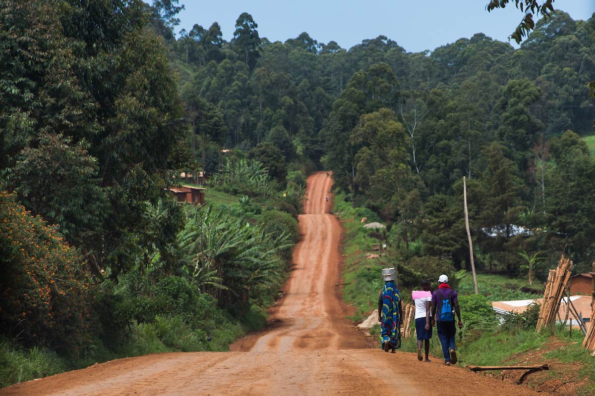 People carrying supplies, walking down the side of a Cameroon road